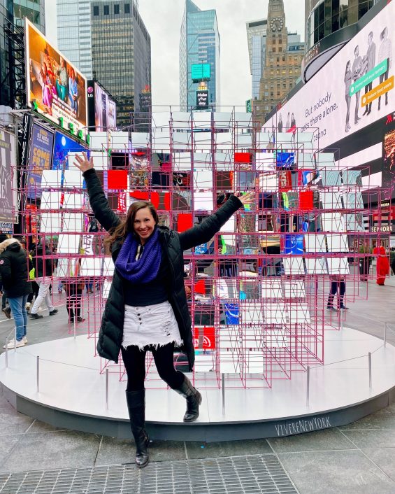 Laura Giromini posing in front of the Heart Squared mirror installation in Times Square, New York City, February 2020