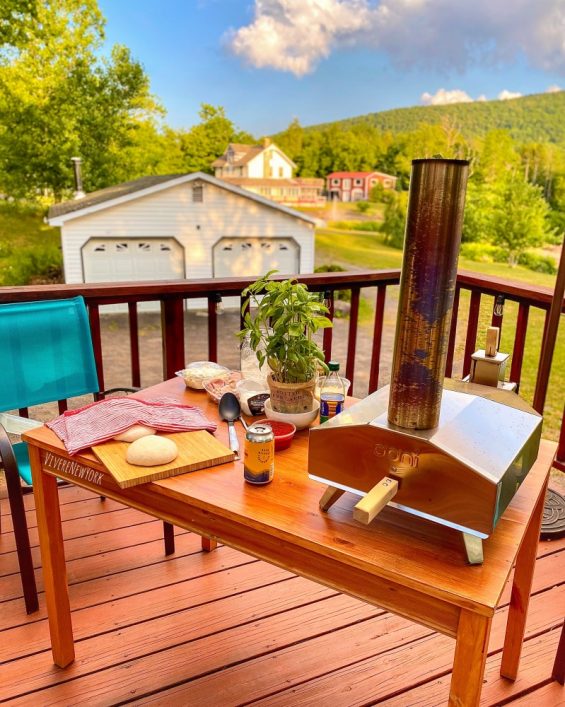 Ooni Fyra portable wood-fired pizza oven on an outdoor terrace, ready to cook Neapolitan pizza